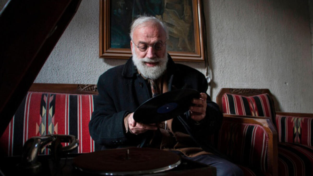 Mohammed Anis puts a record on his trusty gramophone at his home in Aleppo. His family gone, his home bombed out, the record player is one of the few things still working - and a main source of joy for him.