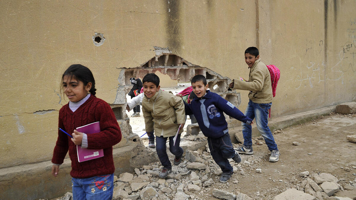 Children run through a huge hole in a wall at the school in Kobani. The Kurdish People’s Protection Units (YPG) reopened the first primary school in 2015, following the defeat of Daesh.