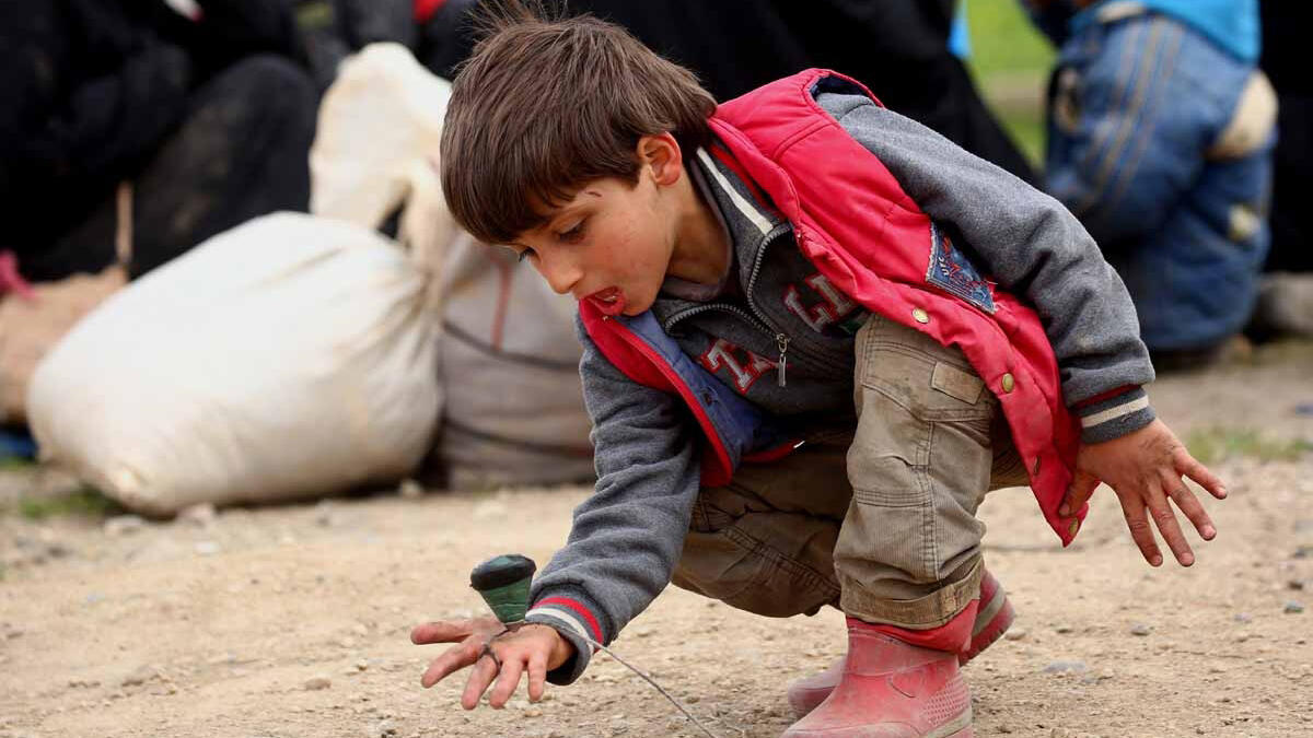 A displaced Syrian boy, who fled Daesh stronghold Raqa, plays with a spinning top at a temporary camp in Syria. Photographer Delil Suleiman: “Sometimes I witness things that give me hope. I saw a truck that had just come in from Raqa. Dust covered the faces of all those on board. And as soon as the kids got off, two of them started playing.”