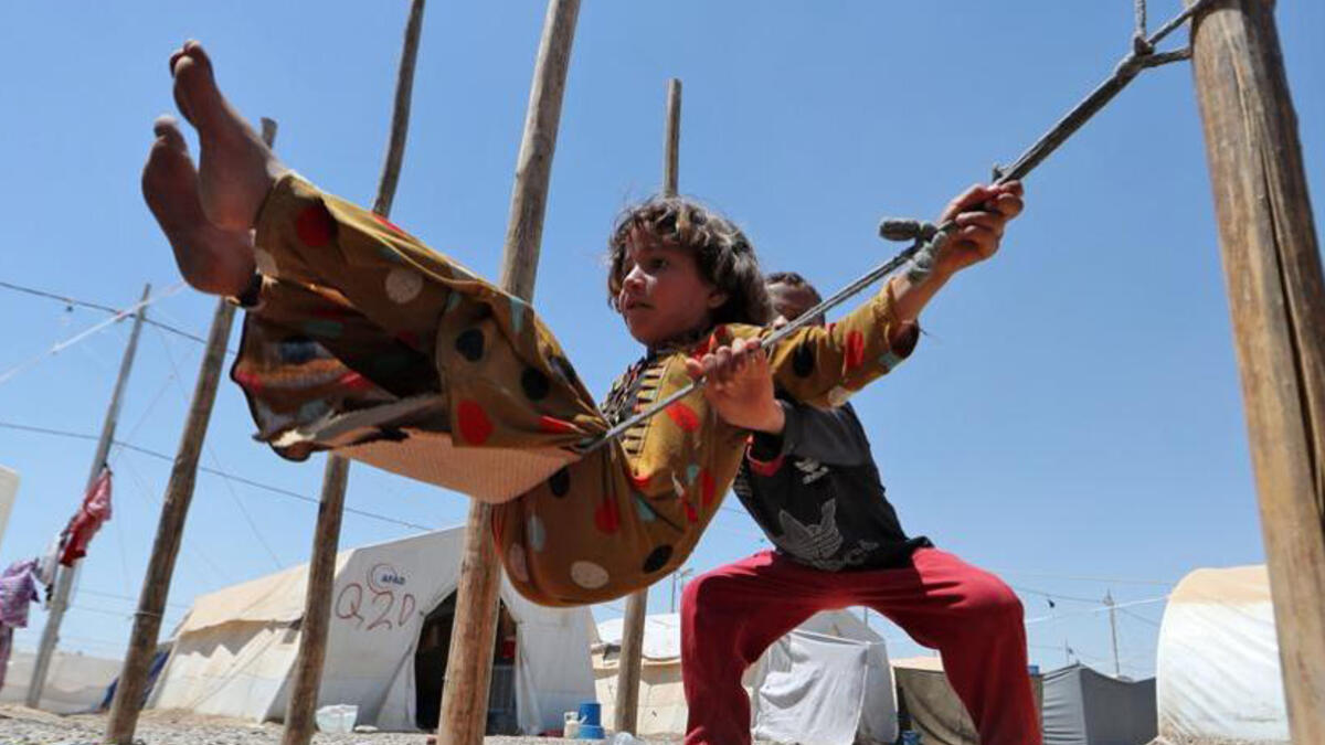 Displaced Iraqi children play on a makeshift swing at al-Khazir camp for the internally displaced, located between Irbil and Mosul. Fighting in Mosul, controlled by Daesh since 2014, has displaced as much as 255,000 people since last October.
