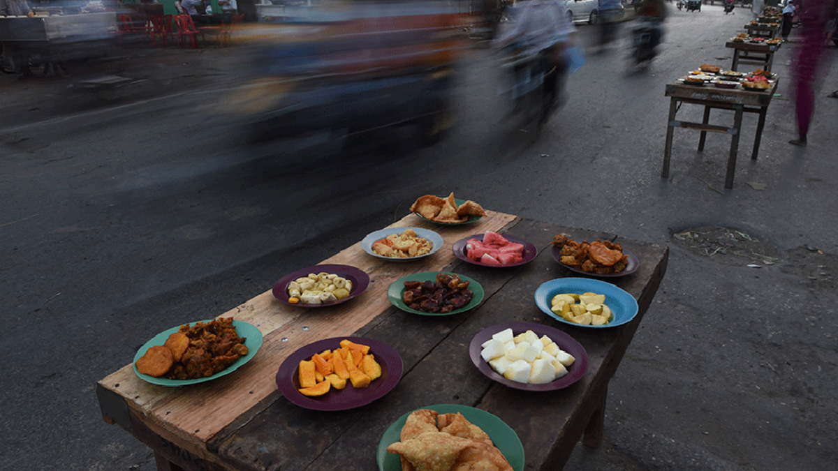 A table in the streets of Karachi, Pakistan, is stuffed with traditional food for Ramadan including samosas (deep fried pastry wraps, filled with minced meat and/or vegetables), pakora (sliced vegetables, dipped in batter and deep-fried) or chatni and namak para (seasoned cracker). Popular sweets during Ramadan include Jabeli.