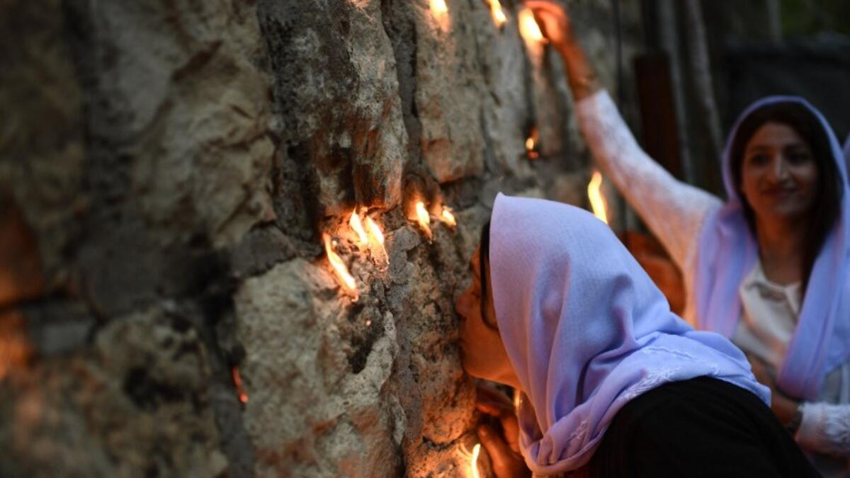 Yazidis kiss the Lalish temple, the place where it is believed that the Peackock Angel, God's representative on earth, descended to bless the earth with fertility and renewal.
