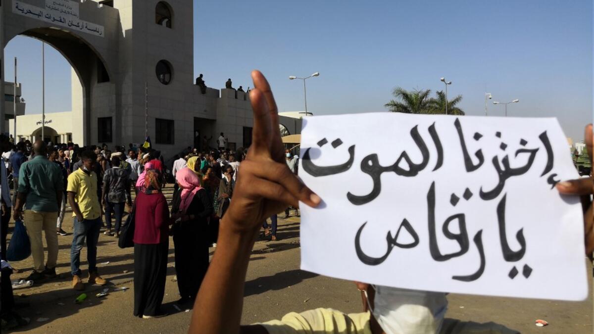 A Sudanese protester holds a placard during a demonstration in front of the military headquarters in the capital Khartoum on April 9, 2019. The writing on the placard reads in Arabic : "We have chosen death, hey dancer", referring to the president. 
STRINGER / AFP