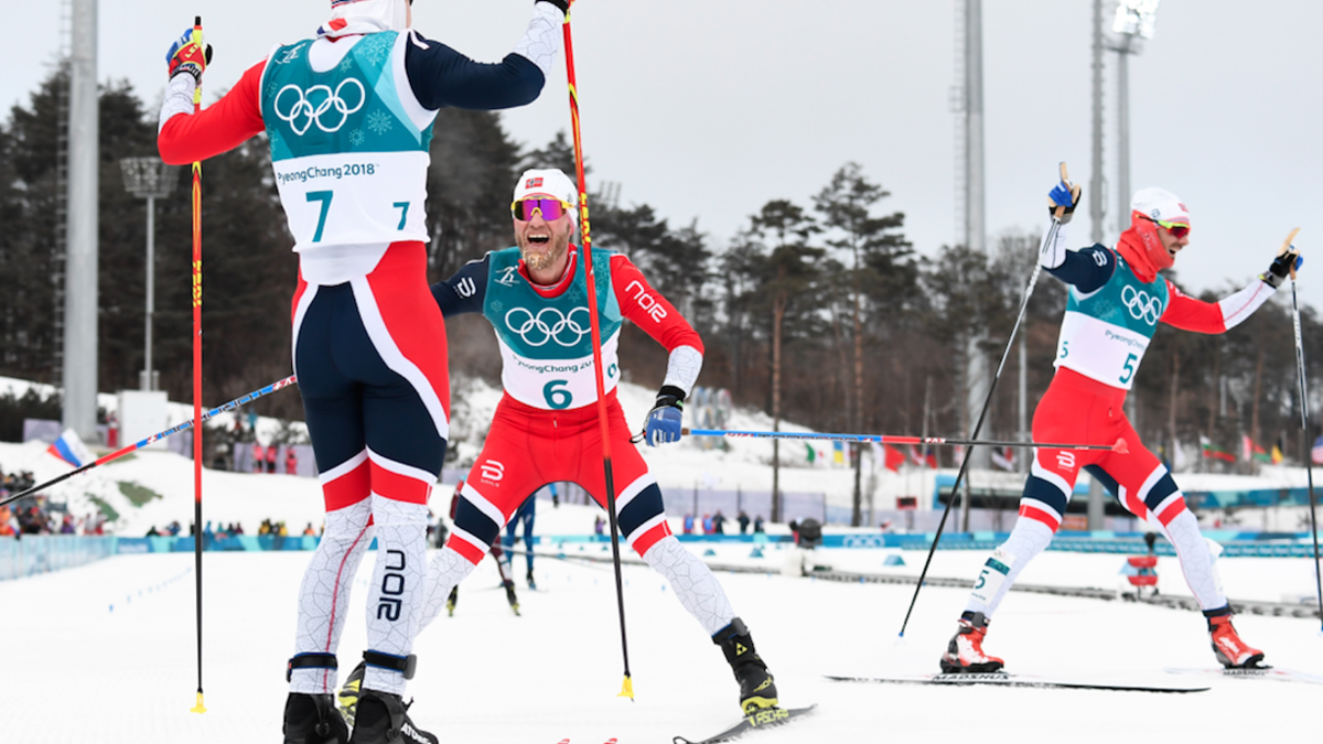 Norway's Simen Hegstad Krueger gold medallist, celebrates as countrymen silver medallist Norway's Martin Johnsrud Sundby arrive at the finish line at the end of the men's 15km + 15km cross-country skiathlon during the Pyeongchang 2018 Winter Olympic Games on February 11, 2018. (Jonathan NACKSTRAND / AFP)