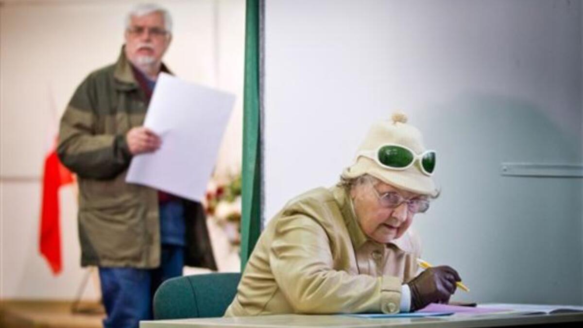 A woman marks her vote on a ballot paper at a polling station in Warsaw during Poland's local elections. Polling stations opened across Poland in the first round of local elections, seen as a key test for the governing liberals before general elections in late 2011.