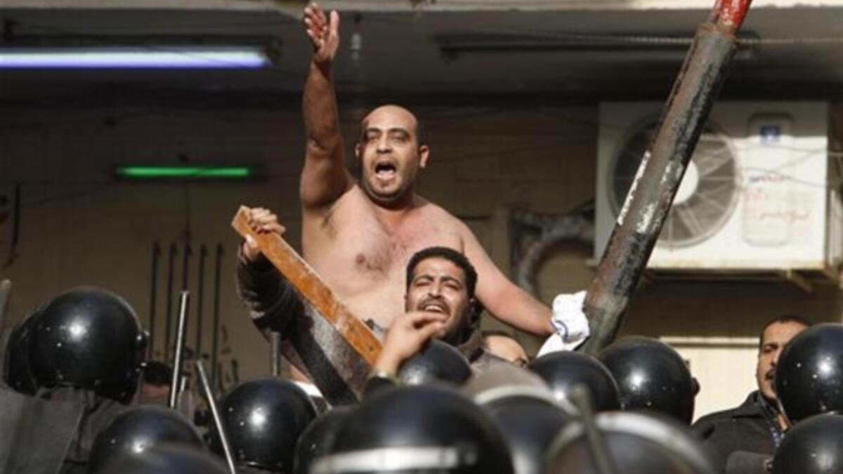 Egyptian Christians face riot police during confrontations outside the Al-Qiddissine church.
