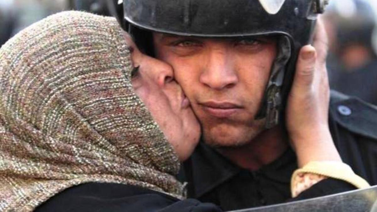 Egyptian woman kisses a security police, Jan 25.