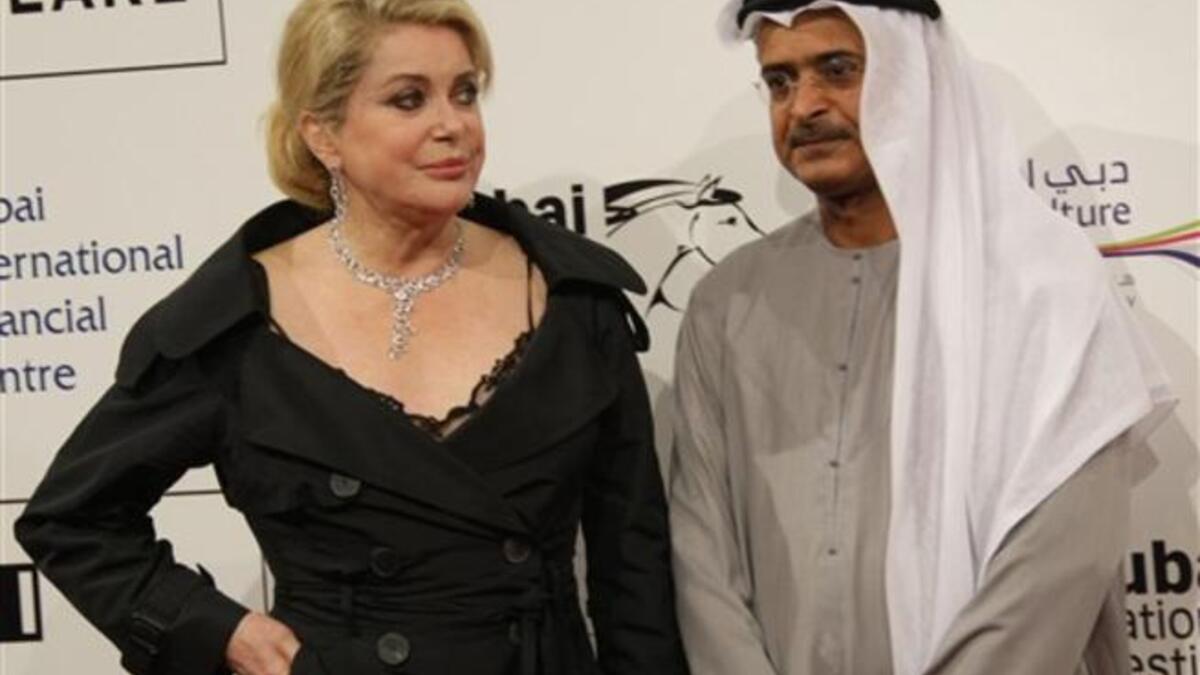 French actress Catherine Deneuve poses for a photograph with the Chairman of the DIFF Abdulhamid Juma.