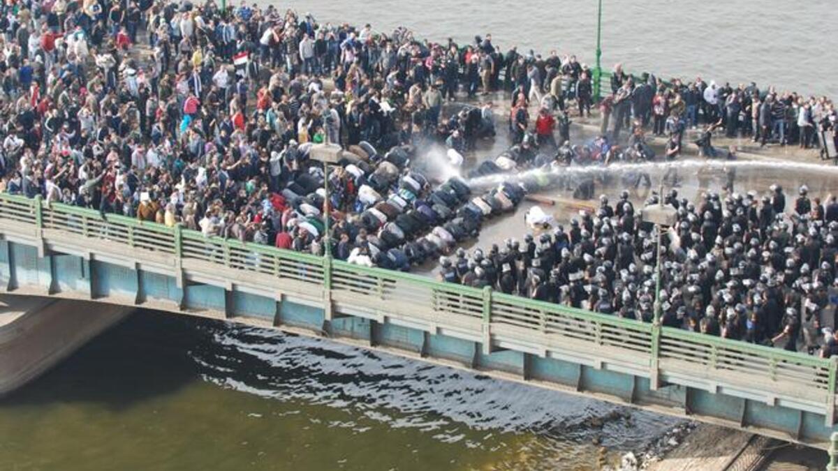 The first tumultuous Friday prayers: supplicating Muslims at prayer take the full force of the water guns on the front line, cushioning  their fellow compatriots.