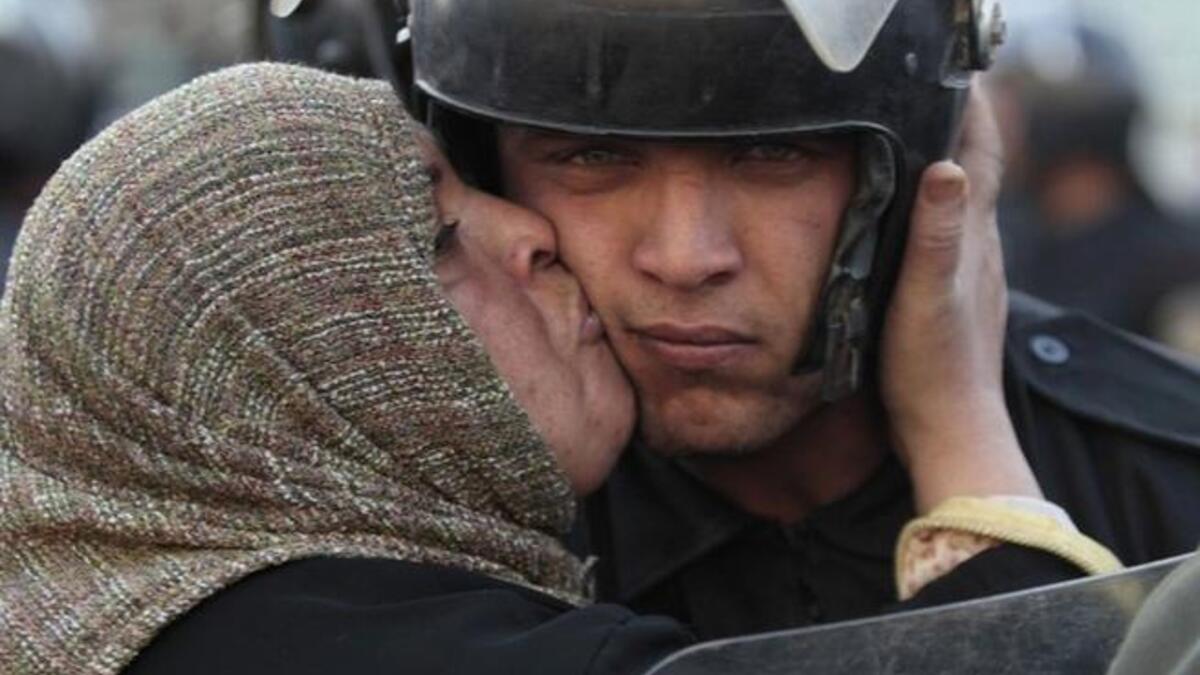 Early days in this marathon display of people power: An Egyptian woman guilts the patrolman into re-considering his stance,through a message of admonition in a firm kiss to a befuddled riot-policeman:You are of us and from us,says this charged kiss.