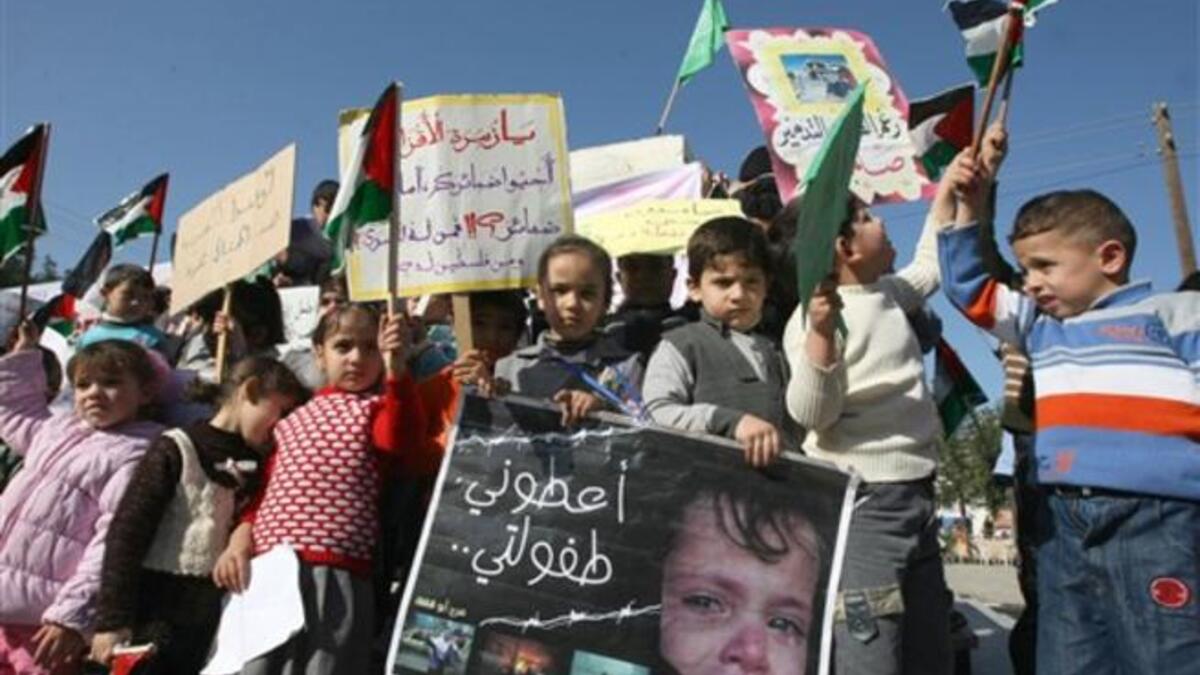 Palestinian children take part in a protest to mark the second anniversary of Israel's three-week offensive, in which over 1000 people were killed, in Jabalia refugee camp, in northern Gaza.