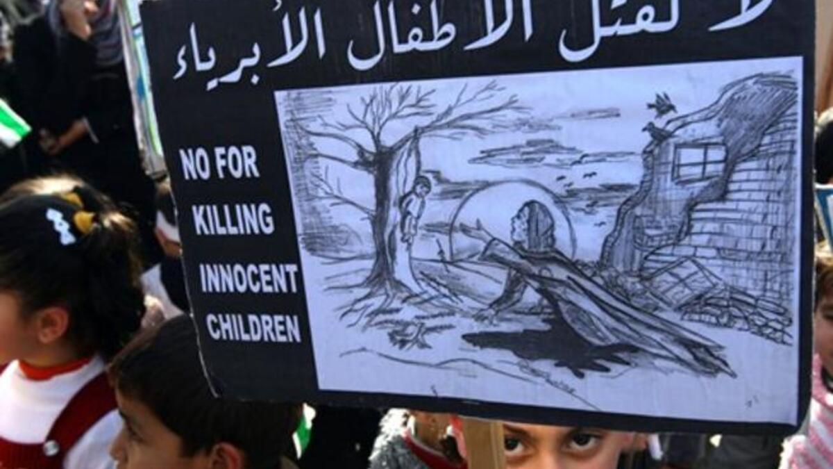 No for killing innocent children sign, held by Palestinian children who took a part in protesting against the invasion of Gaza two years ago.