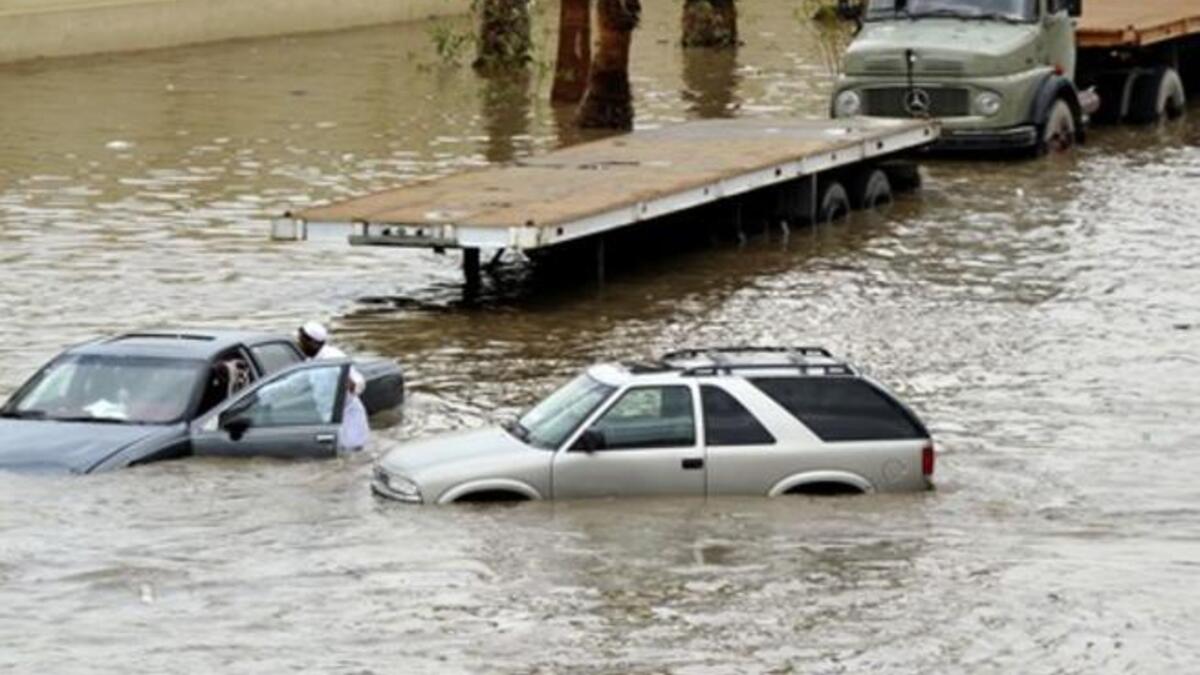 Saudis leave their vehicles in a flooded street following heavy rain in the Red Sea port city of Jeddah.