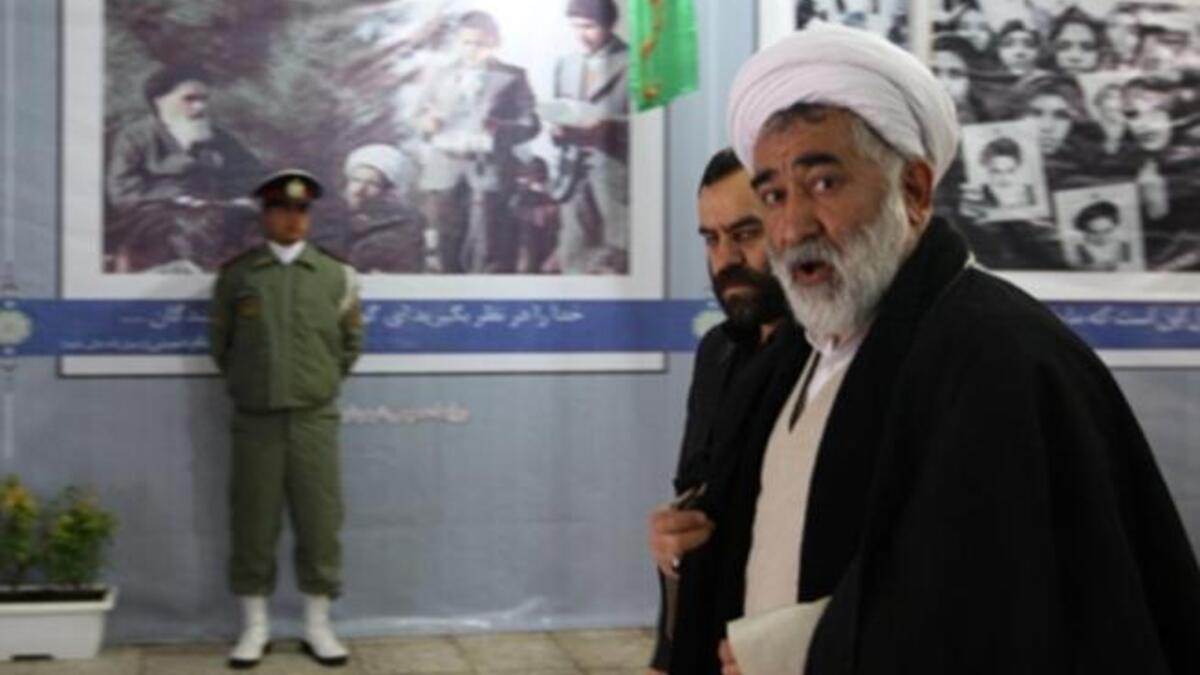Clerics walk past posters showing the late founder of the Islamic Revolution Ayatollah Ruhollah Khomeini, outside Khomeini's mausoleum as they arrive to attend the ceremony.