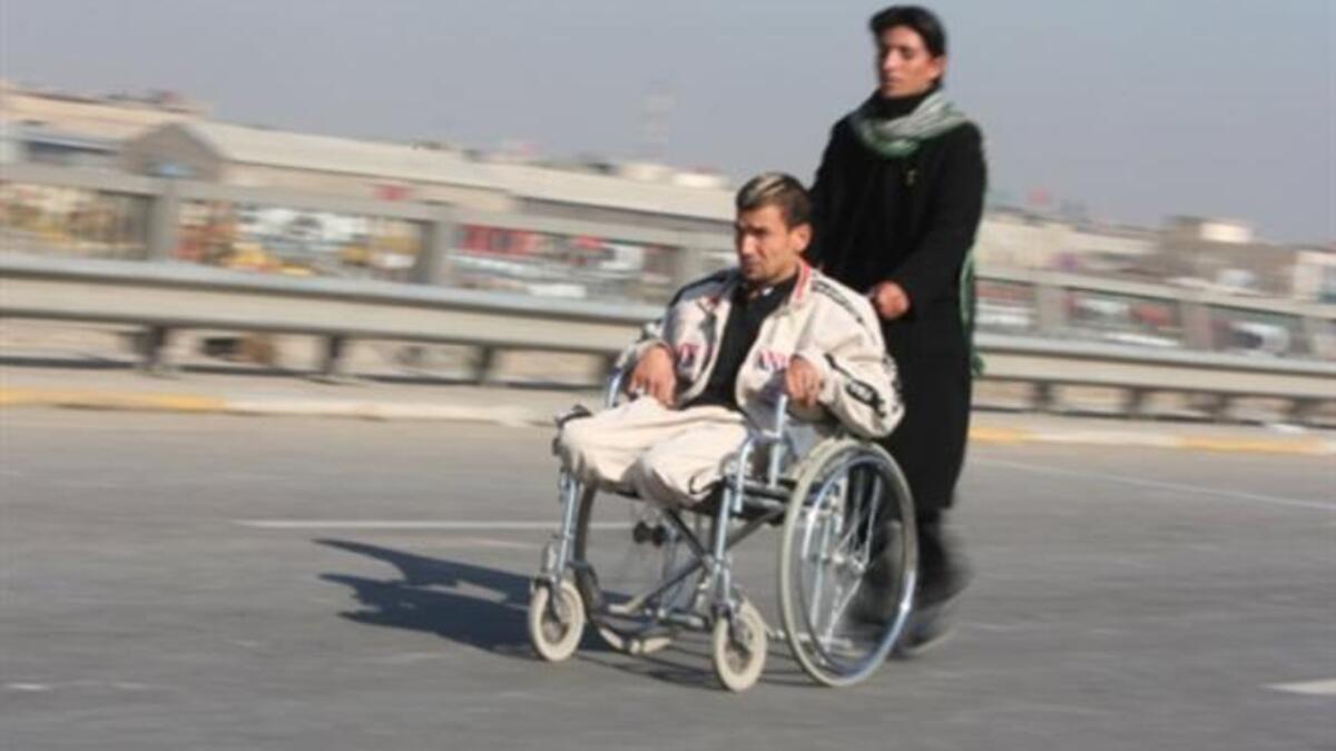A handicapped Shiite pilgrim is pushed on a wheelchair on a highway linking Baghdad to Karbala, 120 kms south of the capital.