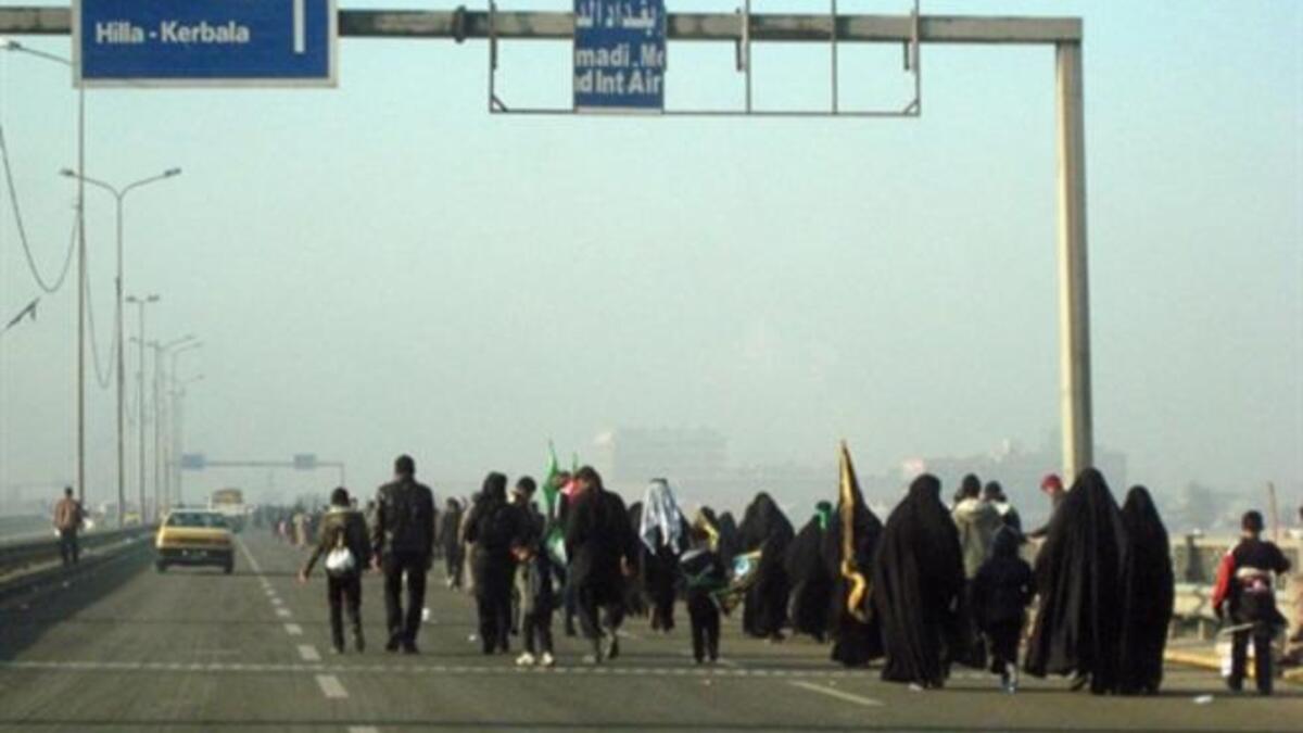 Shiite Muslim pilgrims walk on a main highway linking Baghdad to the central shrine city of Karbala, 120 kms south of the capital, on their way to attend the upcoming Arbaeen religious festival which marks the 40th day after Ashura.