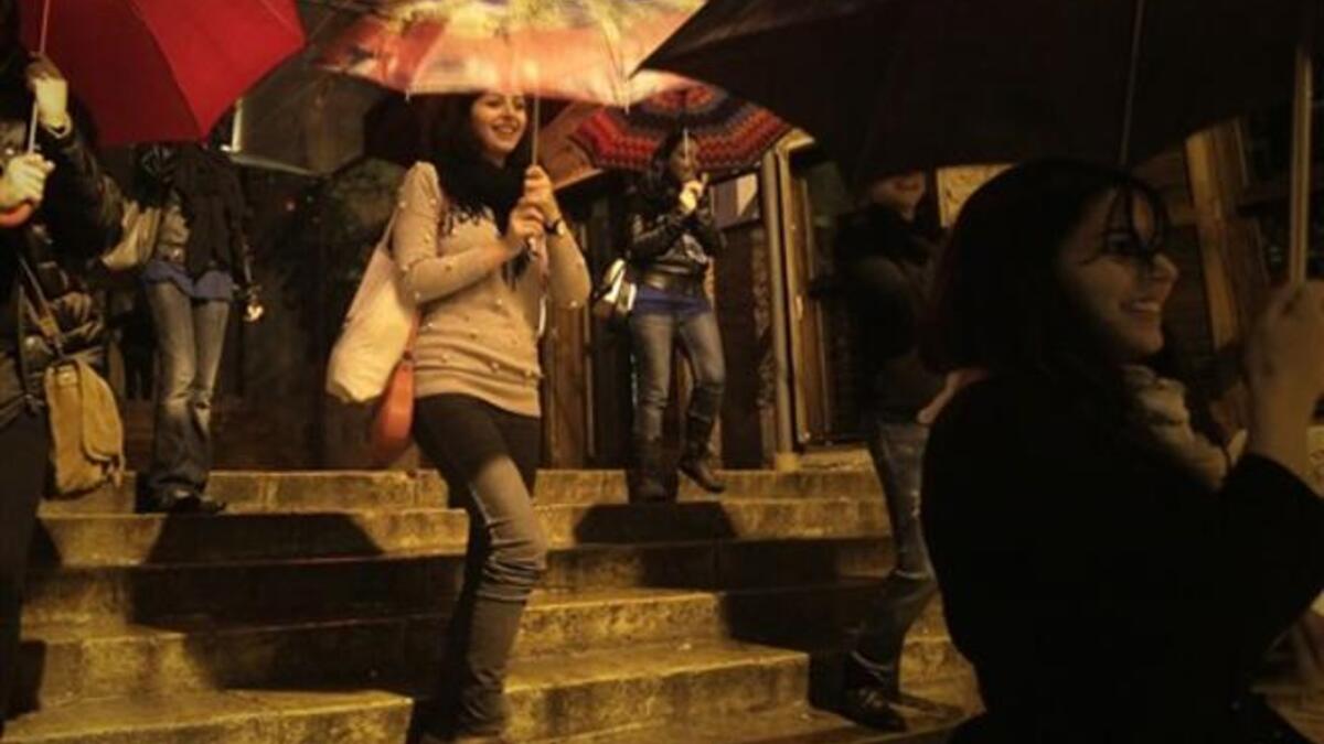 Lebanese women perform a dance in a street as rain approaches the mediterranean country after several months of drought.