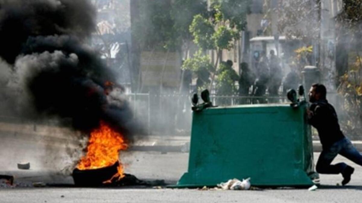 A garbage skips is pushed along a street as supporters of the Future Movement gather in a neighborhood in the capital Beirut during a demonstration in support of the caretaker prime minister Saad Hariri.