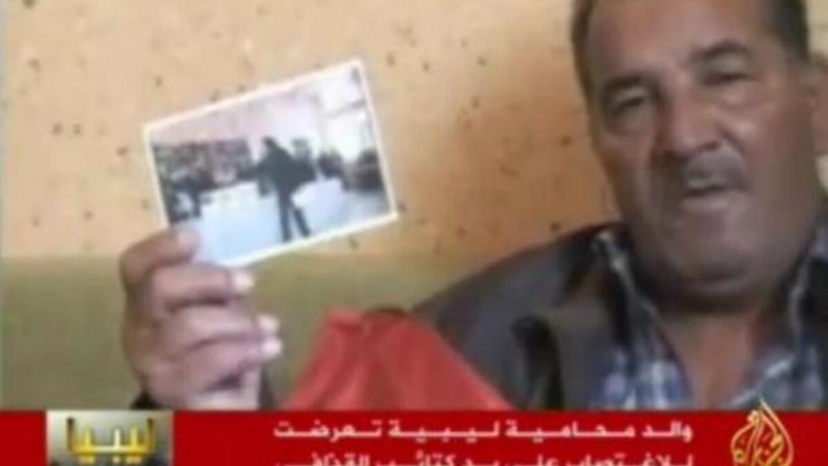 والد العبيدي يرفع صورتها أثناء تخرجها من كلية الحقوق وينفي أن تكون متخلفة عقليا.