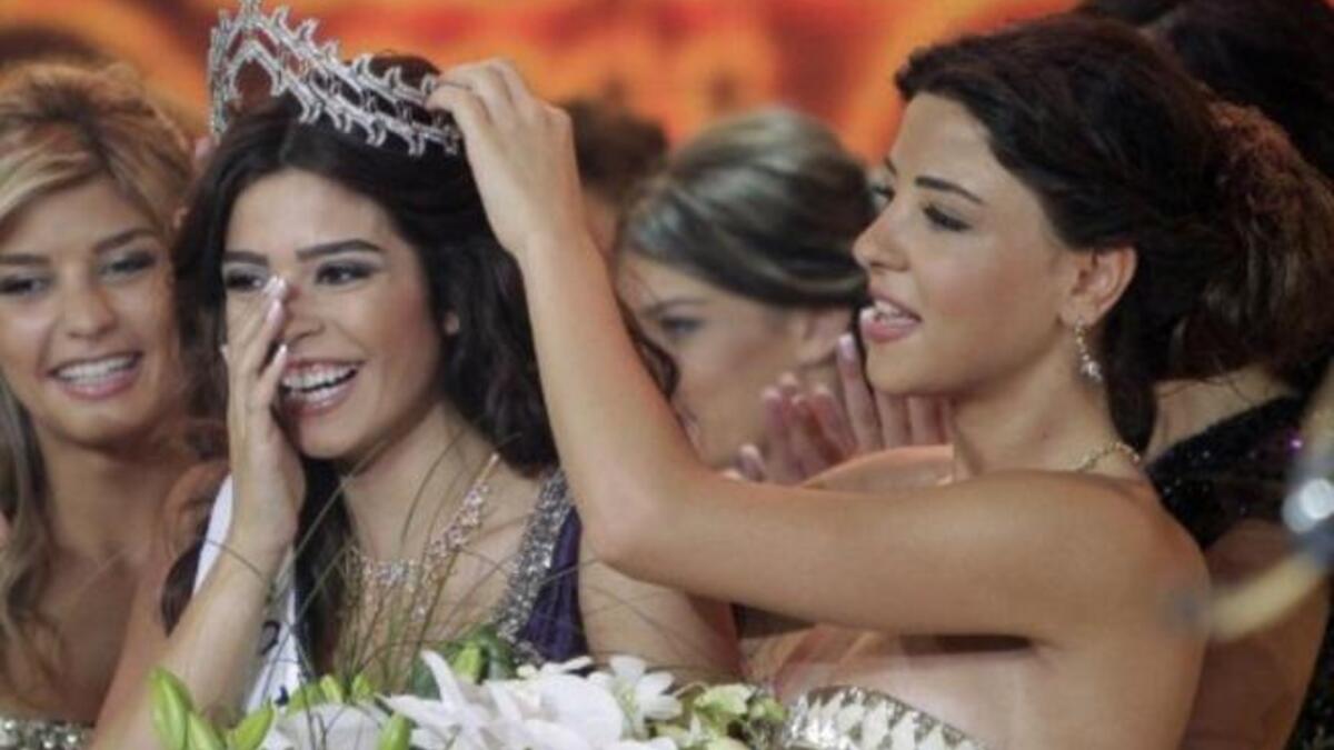 Miss Lebanon 2010 Rahaf Abdallah (R) crowns Yara Khoury Mikael after winning the Miss Lebanon Pageant 2011 beauty contest.
