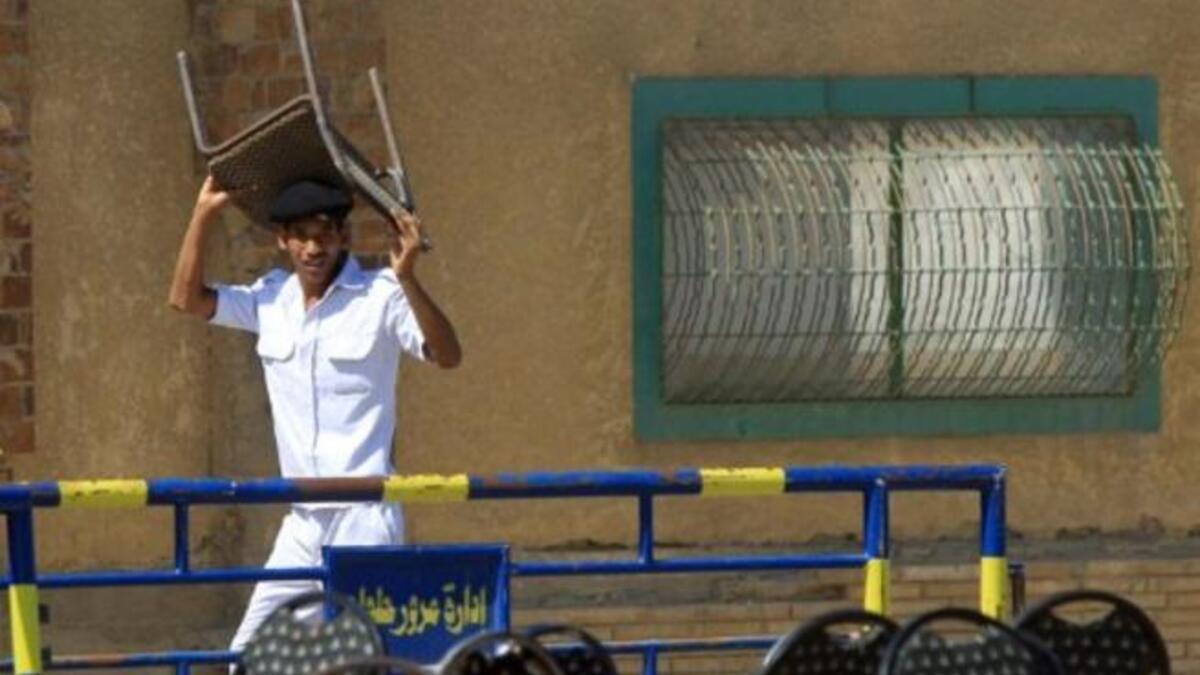 An Egyptian policeman takes cover during clashes between supporters of the former Egyptian president and foes outside the police academy where the ex-president and his two sons are being tried.
