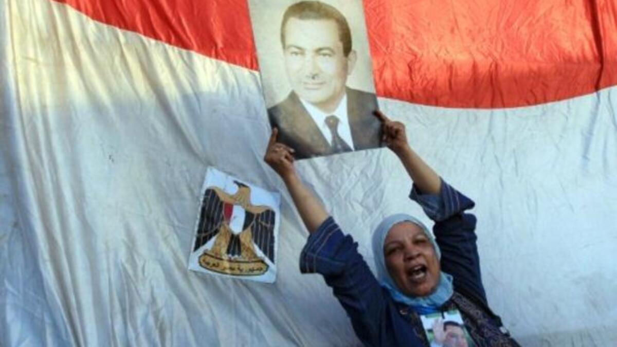 A supporter of ousted Egyptian President Hosni Mubarak holds his picture outside the police academy where Mubarak's trial is held on the outskirt of Cairo.