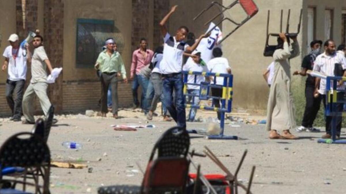An Egyptian supporter of the former Egyptian president throws a chair as clashes erupted between loyalists and foes of Egypt's former president who is being tried on murder charges.