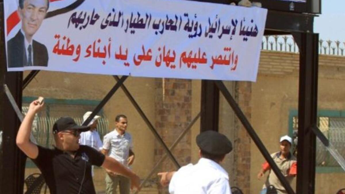 Egyptian supporters of former president Hosni Mubarak (banner) throws a stone as clashes erupted between loyalists and foes of Egypt's former president Hosni Mubarak .