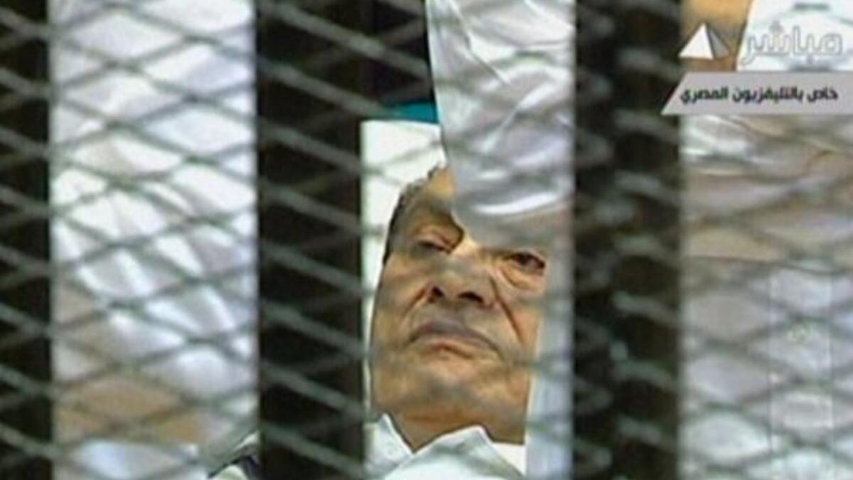 Egyptian former president Hosni Mubarak lies on a stretcher as he listens to the opening proceedings in a holding cell in the court room in the police academy. Comments emerging by the news-hungry public and media highlighted his dyed black hair- in spite of his invalid and ailing condition.