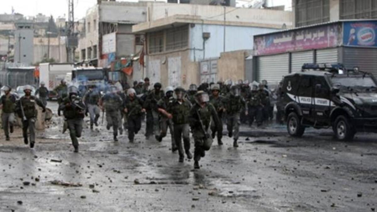 Jerusalem Jossles with its occupied side : Israeli border police take position during clashes with Palestinian demonstrators in the Shufat refugee camp on the outskirts of Jerusalem on May 15.