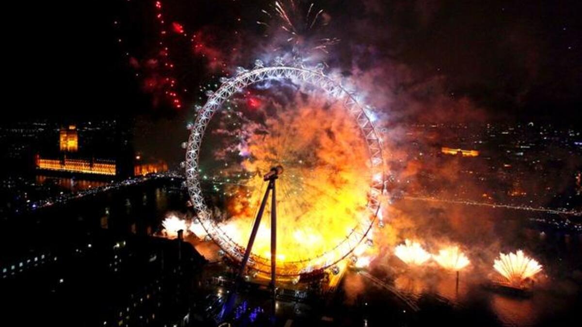 Fireworks light up The London Eye ferris wheel just after midnight in London, England.