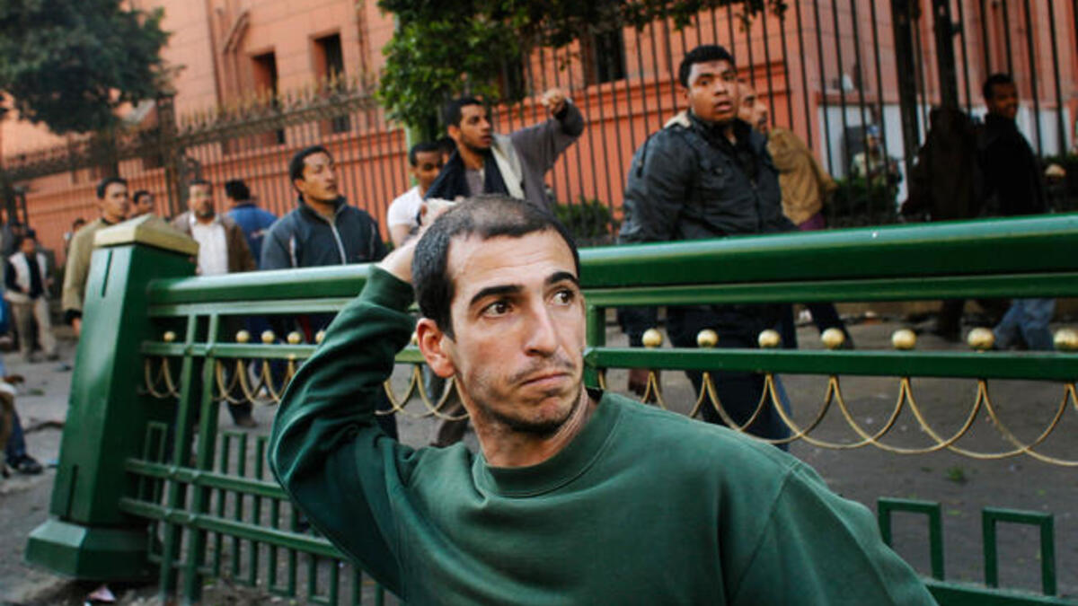 Anti-Mubarak protesters throws rocks at pro-government supporters during a clash between pro - and anti - Mubarak protesters.