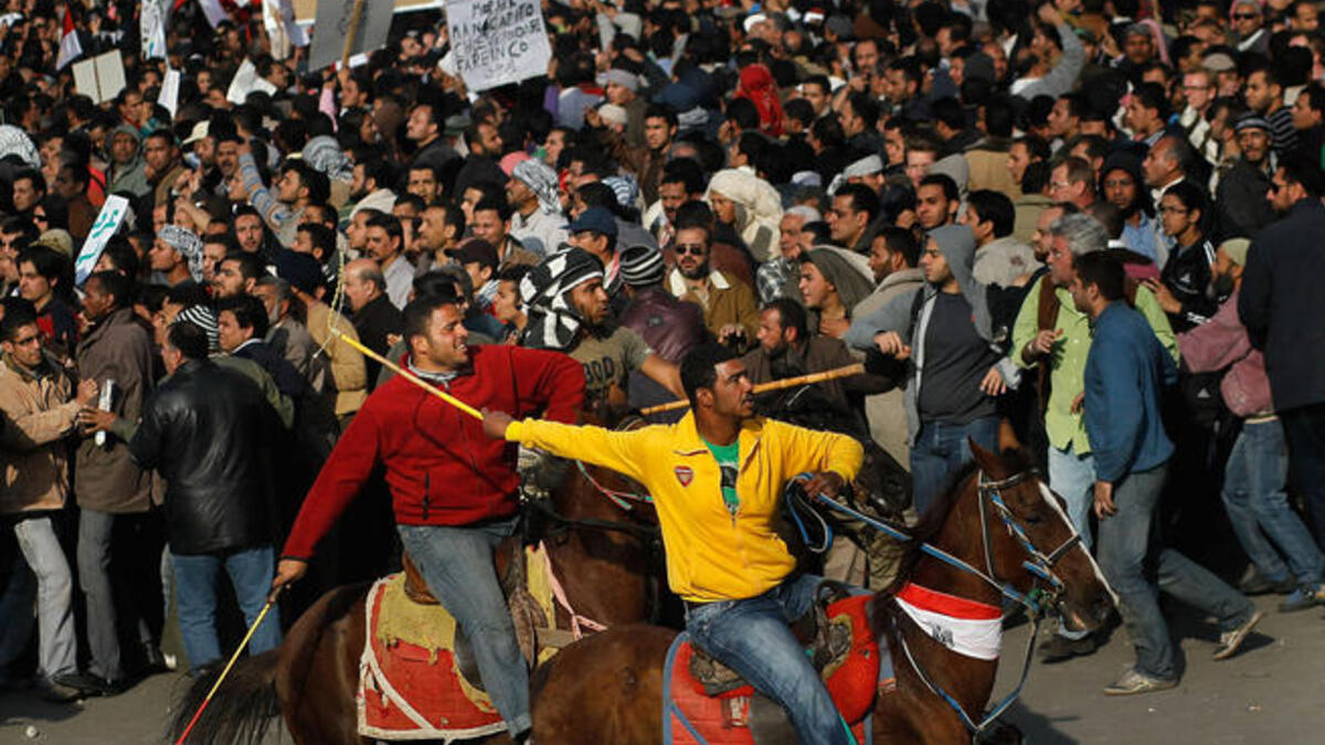 Supporters of embattled Egyptian president Hosni Mubarak ride horses through the melee during a clash between pro- and anti-Mubarak protesters.