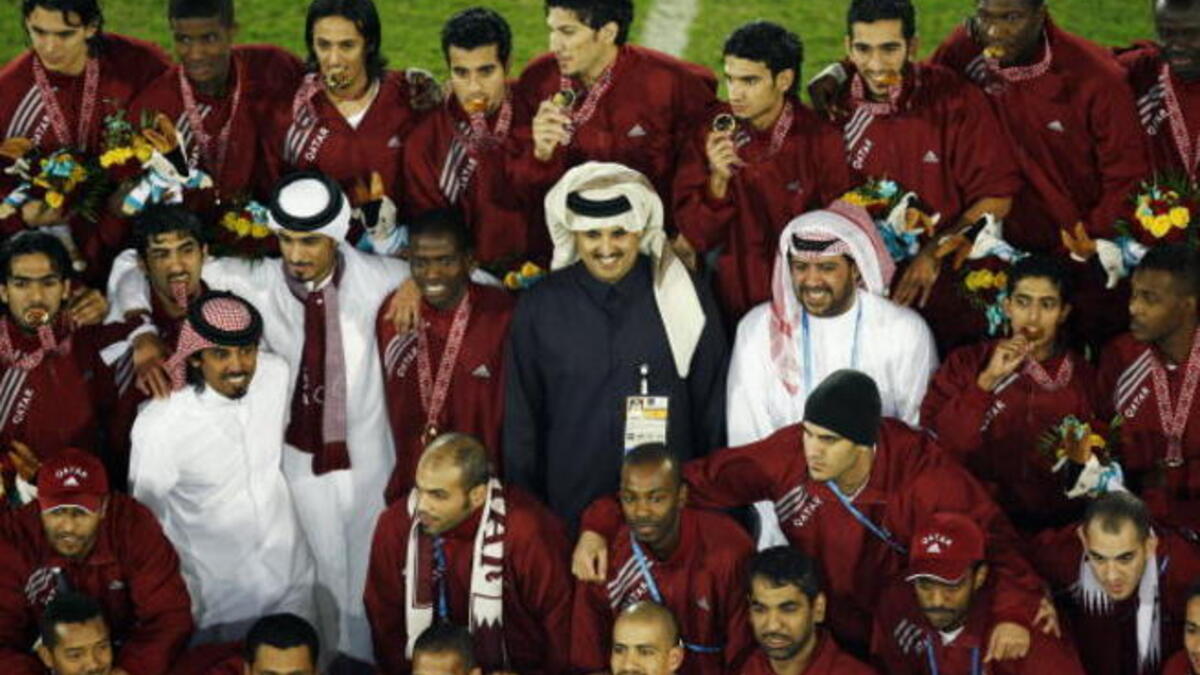Sheikh Tamim Bin Hamad Al-Thani celebrates with the Qatar team after the gold medal match between Qatar and Iraq (Getty)