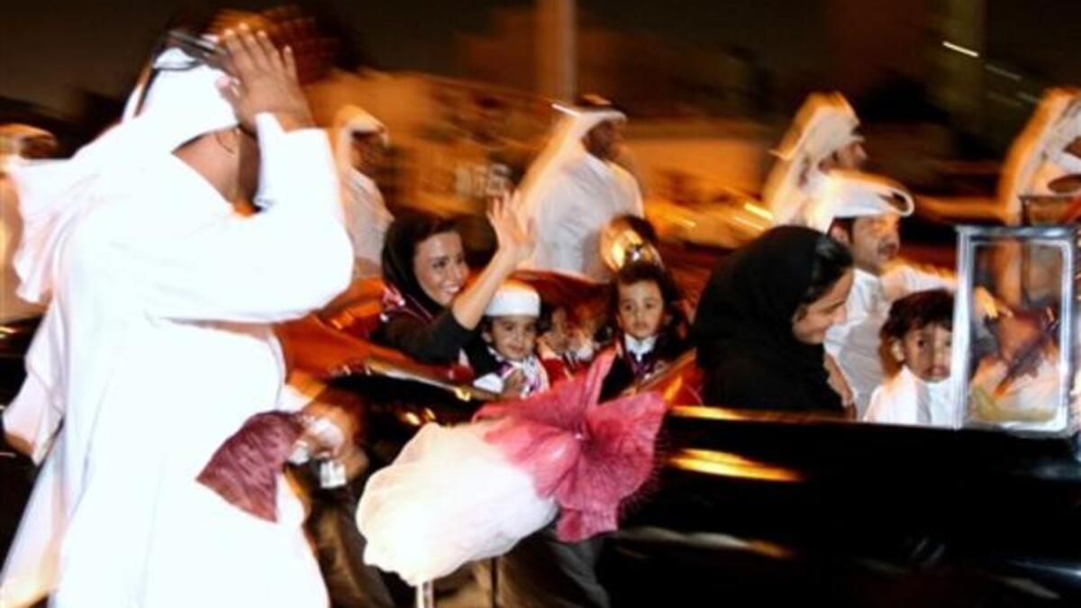Sheikha Moza bint Nasser al-Missned (car L), wife of Qatari Emir Sheikh Hamad bin Khalifa al-Thani, waves to the crowds as she arrives with her grandchildren to Doha coming from Zurich.