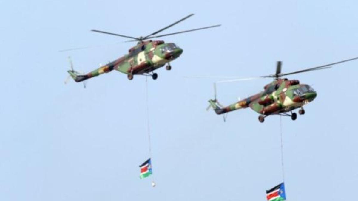 Southern Sudanese military helicopters fly an overpass carrying two Southern Sudan flags during a ceremony in the capital Juba on July 9, 2011 to celebrate South Sudan's independence from Sudan.