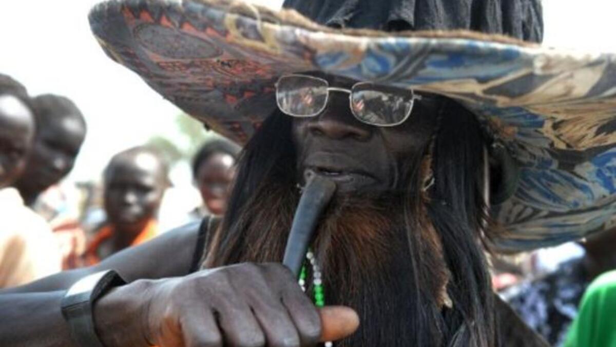 A traditional Southern Sudanese dancer blows into a horn during the ceremony in the capital Juba.