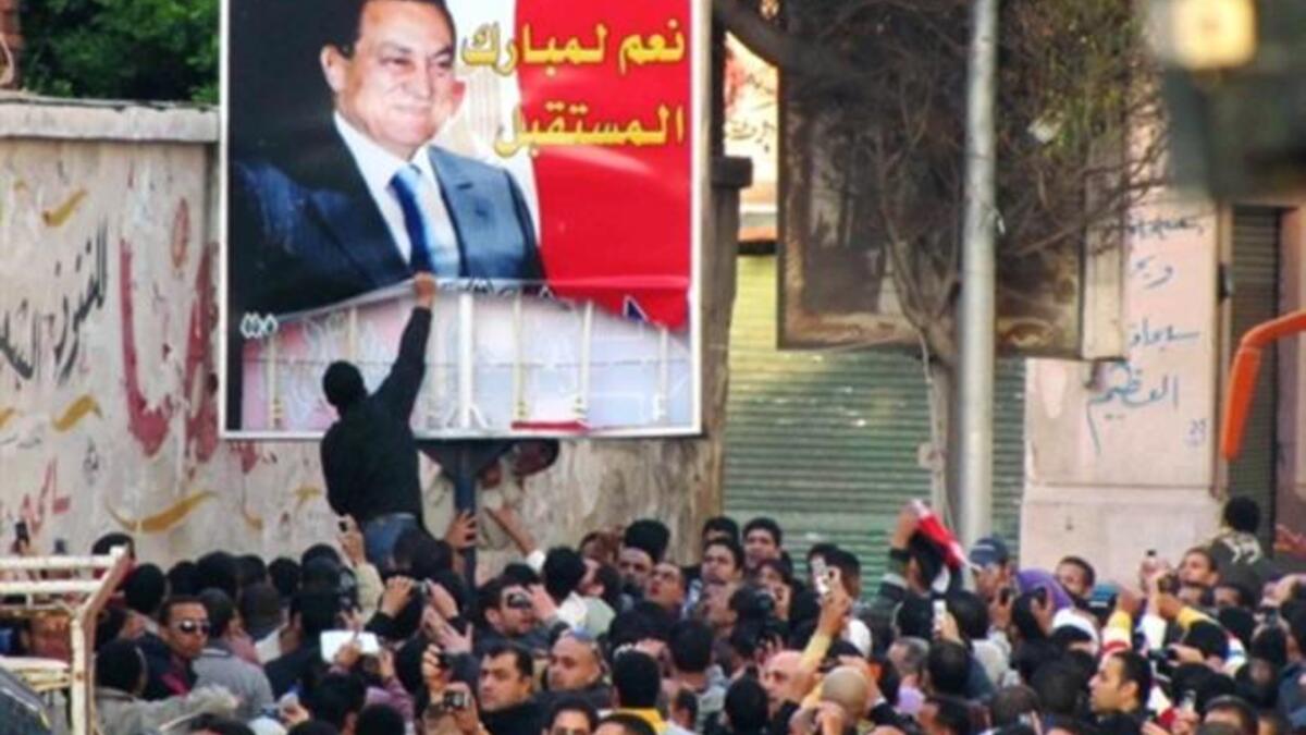 EGYPT: Egyptian demonstrators tear down a poster of Egyptian President Hosni Mubarak in the Mediterranean coastal city of Alexandria on January 25, 2011.