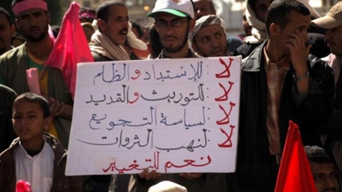 Placard reads: "No Despotism and Unfairness, No to Power Inheritance and Extension No to Starvation Policy, No to Theft of Resources Yes for Change".