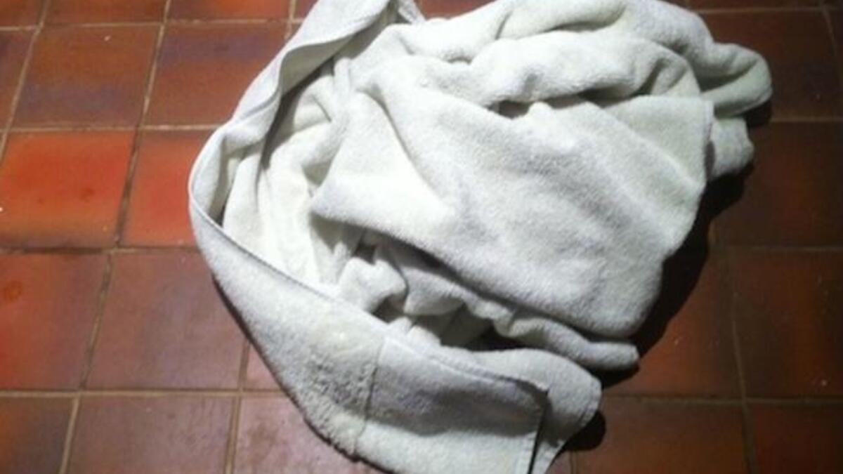 Towels piled on floor outside hotel room