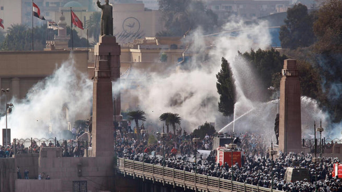 Riot police force protesters back across the Kasr Al Nile Bridge as they attempt to get into Tahrir Square in downtown Cairo, Egypt.