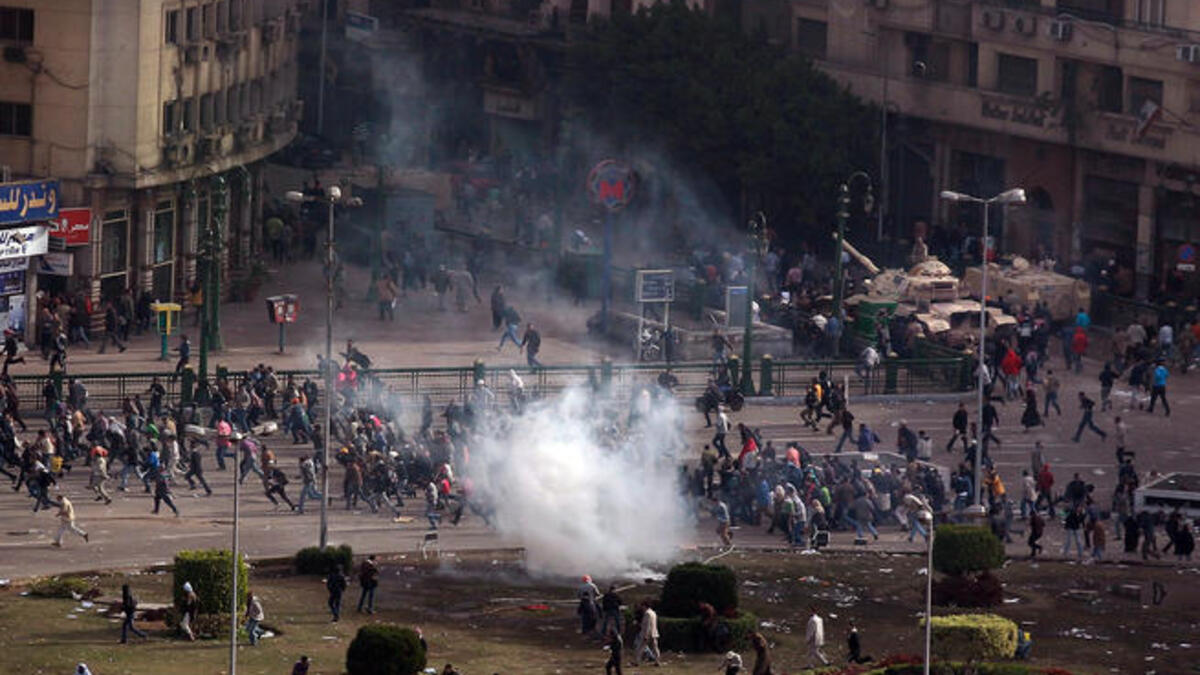 Protesters flee a volley tear gas in Tarhir Square.