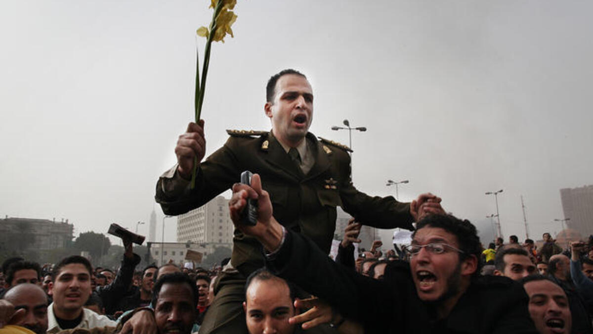 Protesters carry an army captain on their shoulders after he tore up a poster of Egyptian President Hosni Mubarak.