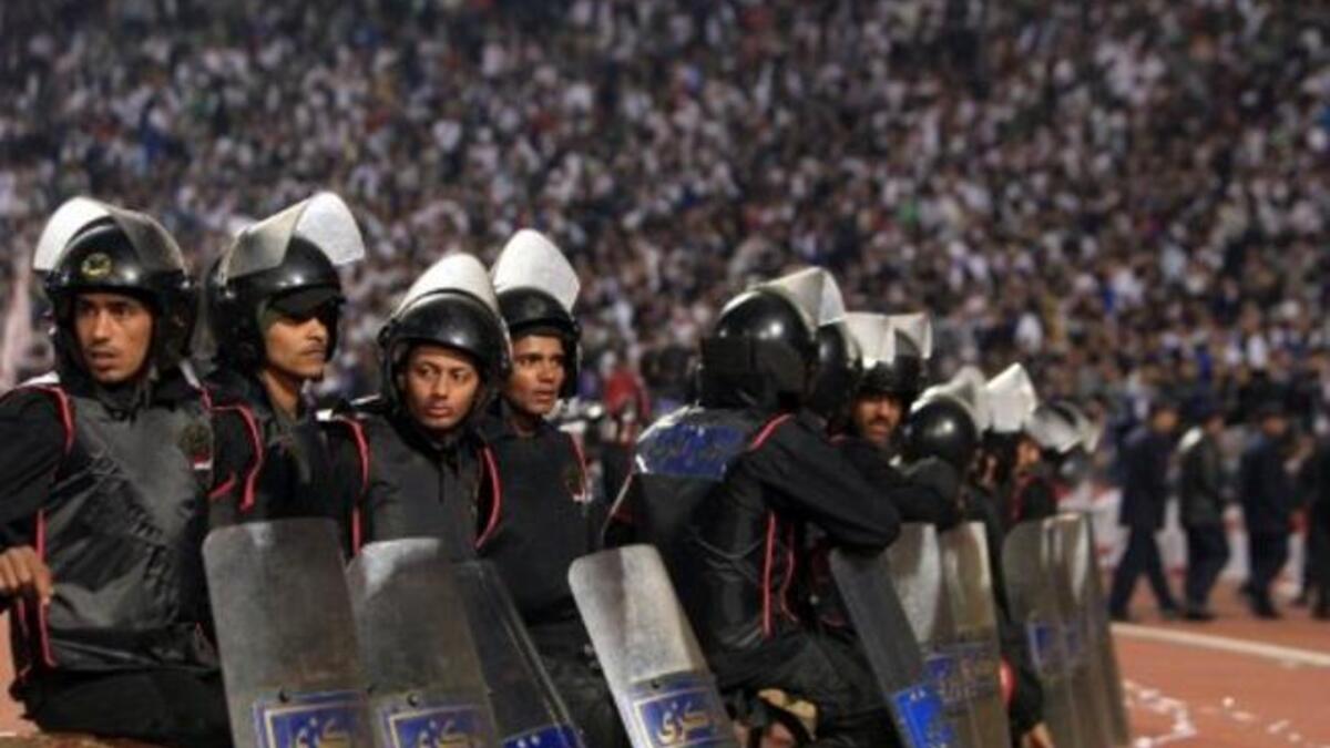 Egyptian riot police: stand guard in Cairo Stadium during the first half of a match between
Zamalek and Ismaili clubs in Cairo. The second half was suspended after events from Port Said filtered over. There was much criticism of the security and police who left their post and bailed as things got out of control.