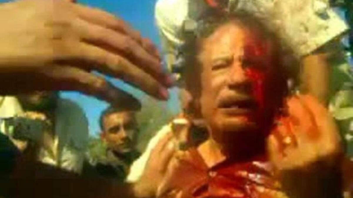 كيف وصل العقيد إلى هذه المصير الدموي؟ ما يزال تسلسل الأحداث غير واضحا بسبب تضارب الأنباء، حيث يقال بأن غارة للناتو استهدفت موكبه في سرت مما دعا مرافقيه للبحث عن مساعدة طبية ساعدت الثوار في العثور عليه ومن ثم إطلاق النار عليه مجددا.