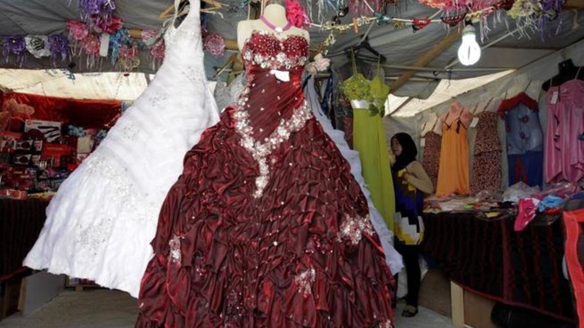 A woman looks at dresses in a covered stall in the northern Jordanian Zaatari refugee camp, now home to 160,000 Syrians (AFP)