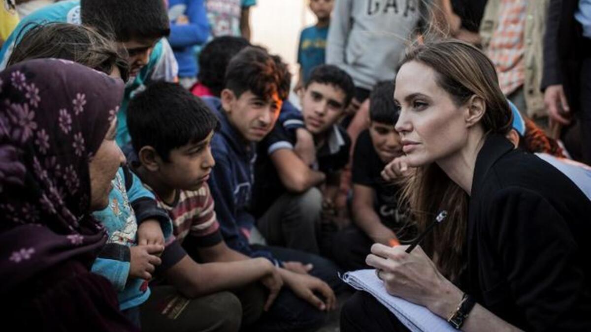 US actress Angelina Jolie listening to Syrian refugees in a Jordanian military camp based the the Jordan-Syria border (UNHCR / AFP)