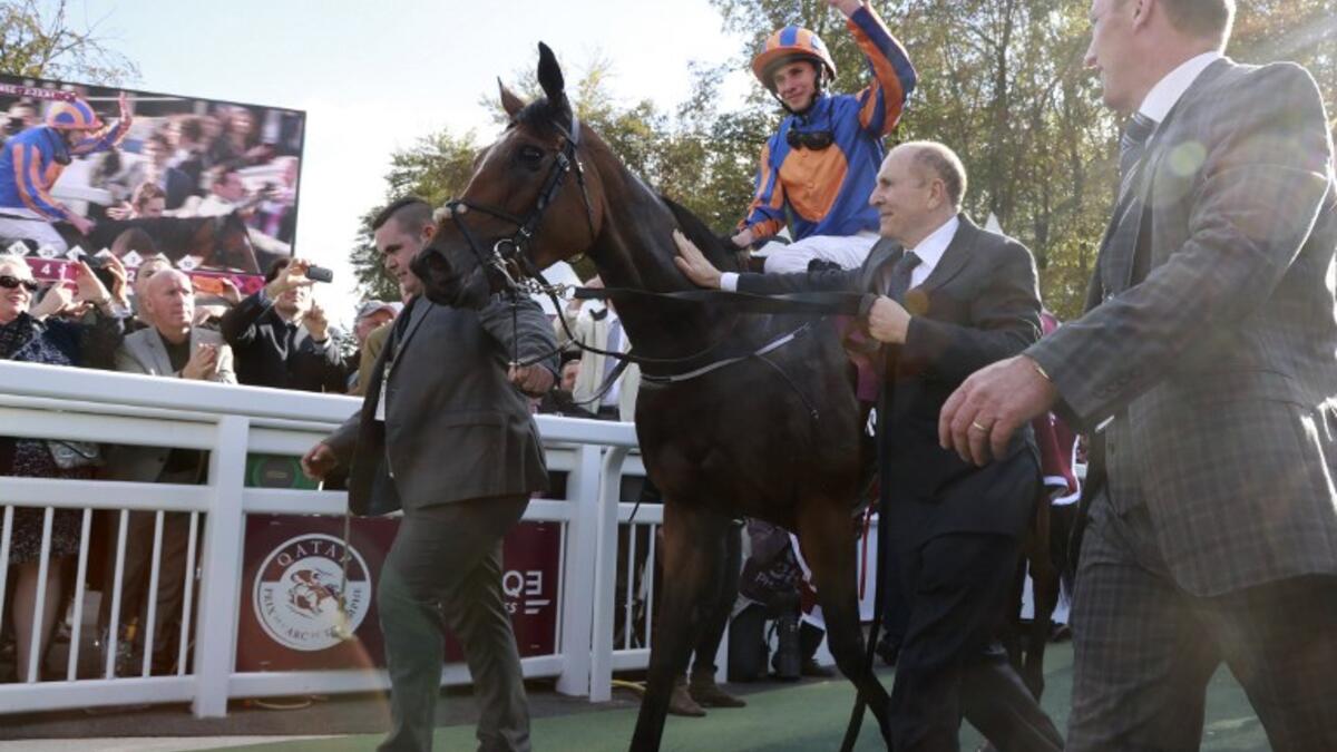 Britain's Ryan-Lee Moore (L) waves on his horse 'Found' as he celebrates winning the 95th Qatar Prix de l'Arc de Triomphe horse race at the Chantilly racecourse, northern France, on October 2, 2016.
JACQUES DEMARTHON / AFP