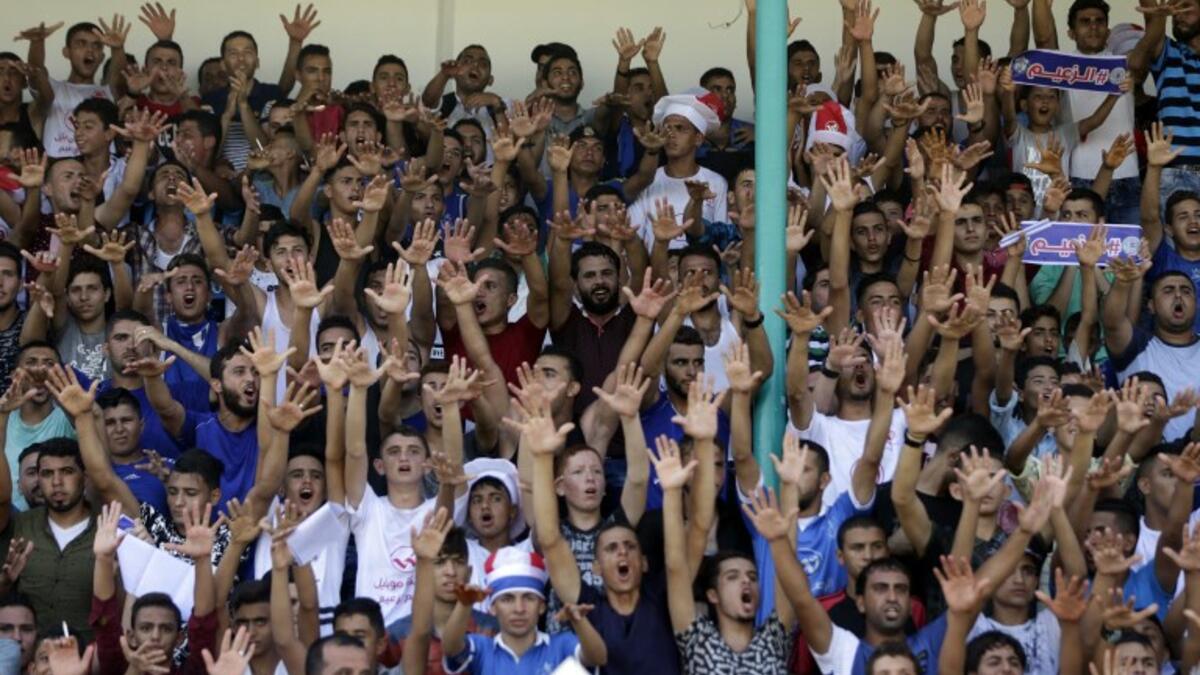 Fans of Shabab Rafah football club celebrate their team's victory against Hebron's Ahly al-Khalil football club in the first leg of the Palestine Cup final at the Yarmouk Stadium in Gaza City on August 1, 2017.
MAHMUD HAMS / AFP
