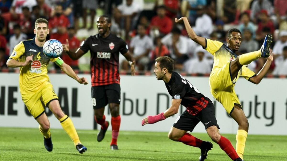 Al-Ahli's Everton Ribeiro (C) fights for the ball against Al-Taawun's Ricardo Tavares Machado (L) and Abdullah Ibrahim Kano (R) during the AFC Champions League group stage football match between UAE's Al-Ahli and Saudi Arabia's Al-Taawun on March 13, 2017, at the Al-Rashid Stadium in Dubai.
STRINGER / AFP